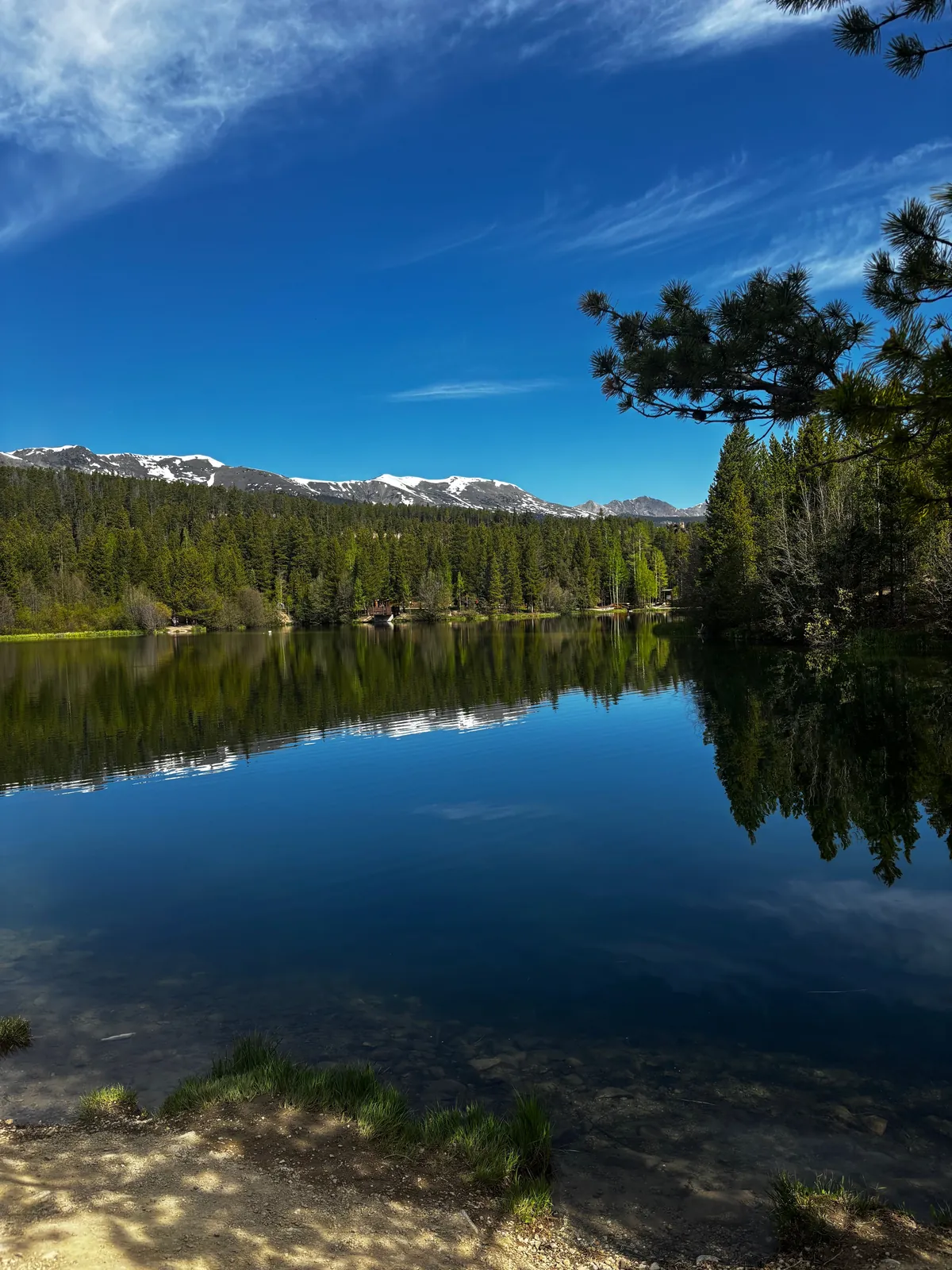 Calm mountain lake reflecting the forest and sky near Breckenridge, Colorado